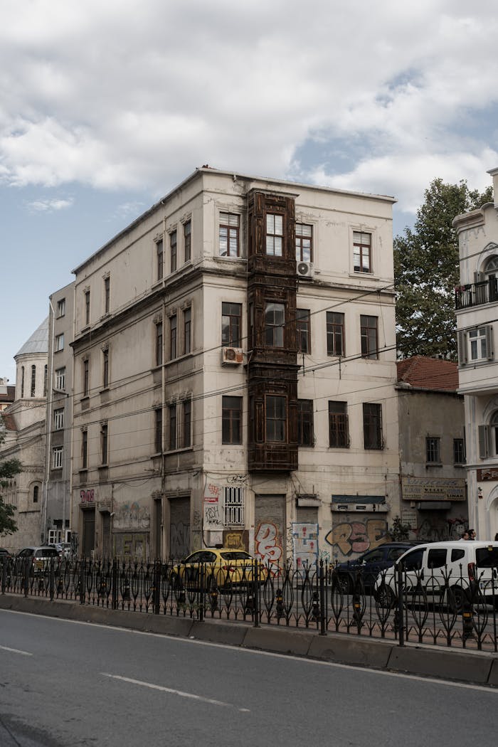 Aged multi-story urban building with graffiti and street view, showcasing historic architecture.